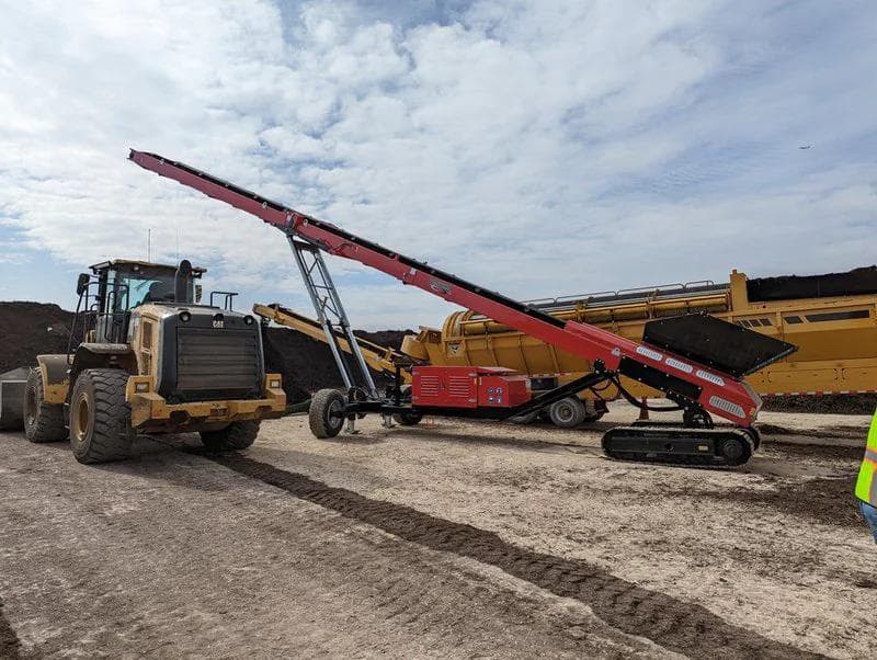 red tracked conveyor being used to stockpile compost
