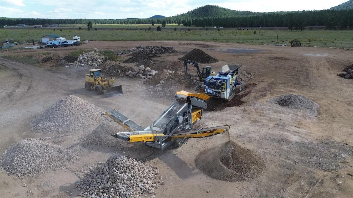 omega j1065t crusher crushing rock and the material being fed into a screener which is separating the material into three different sizes or grades