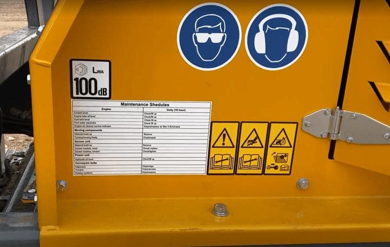maintenance checklist on the yellow barford sr124 screener along with safety stickers and hazard warnings