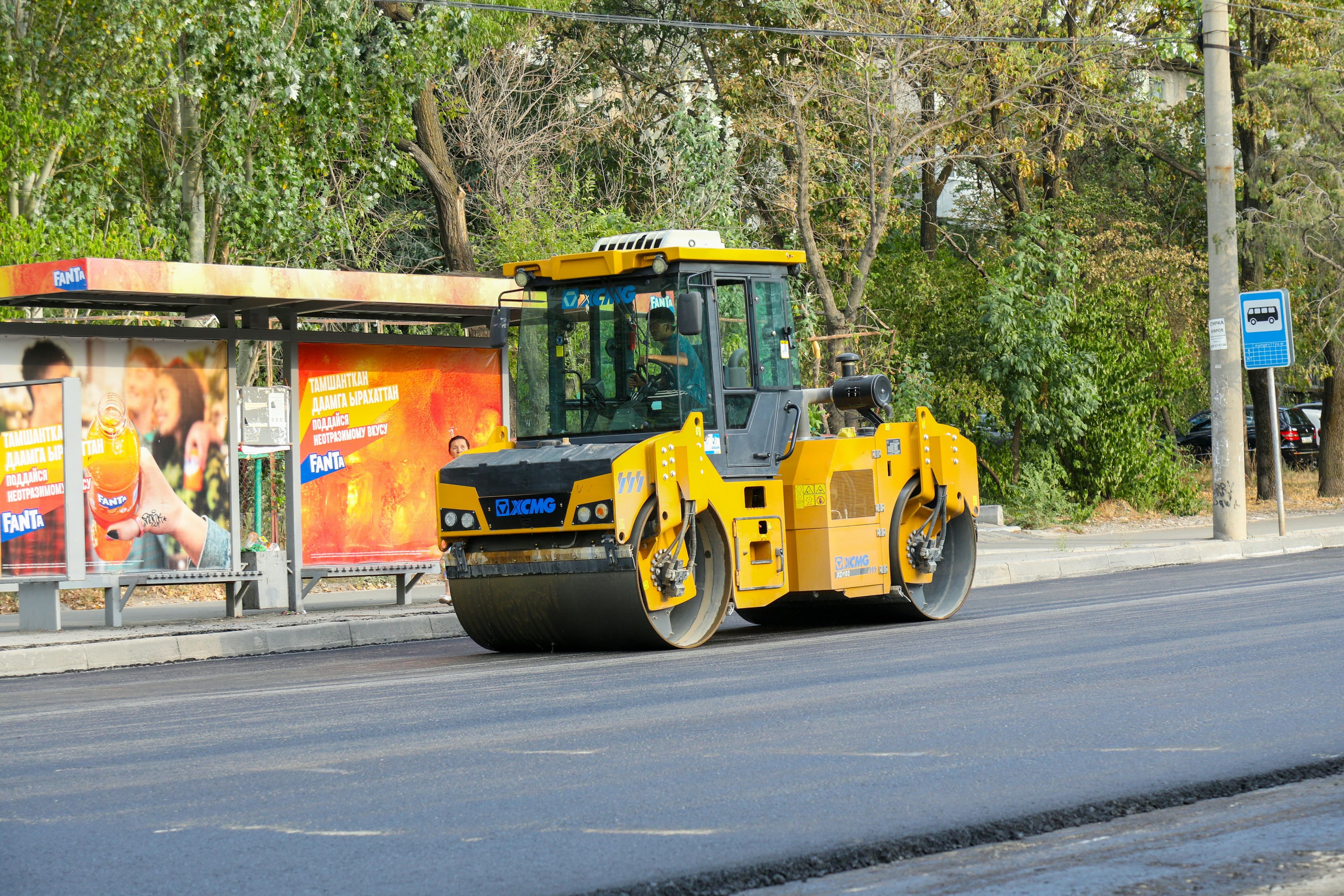 steamroller flattening a road of asphalt