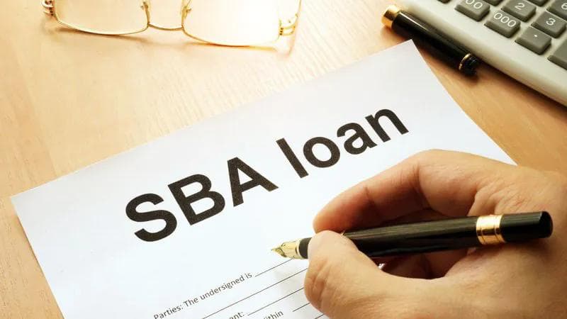 man signing a SBA 504 agreement with a black fountain pen