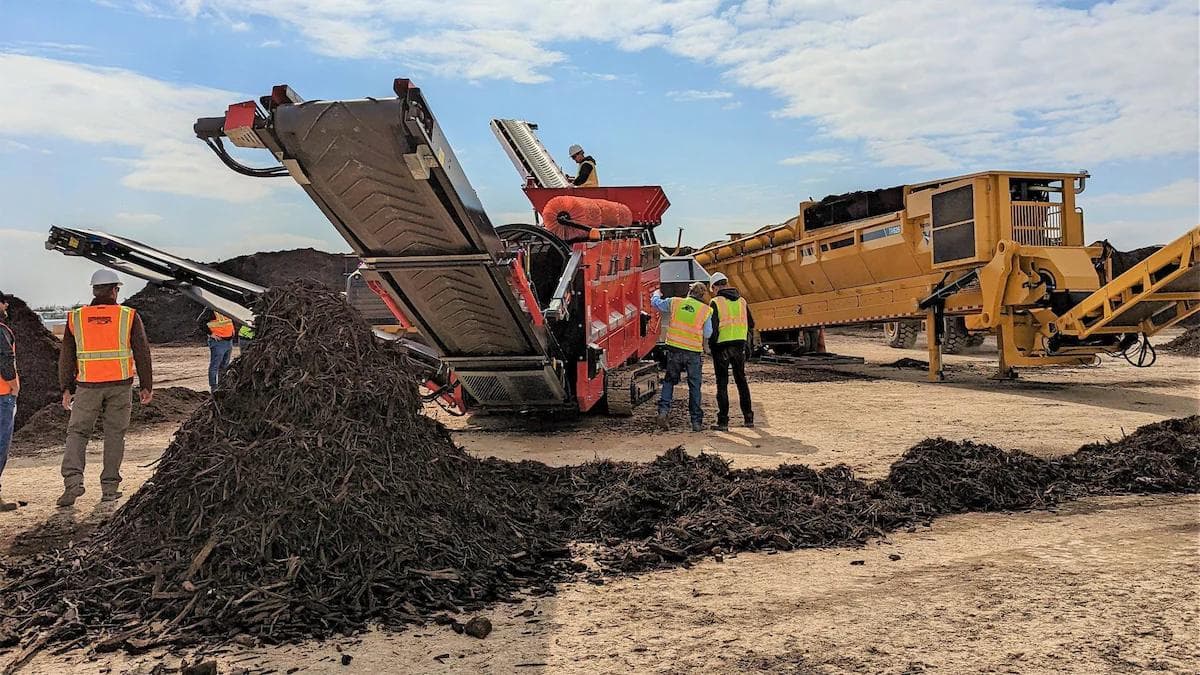 Large orange trommel screener screening compost onsite