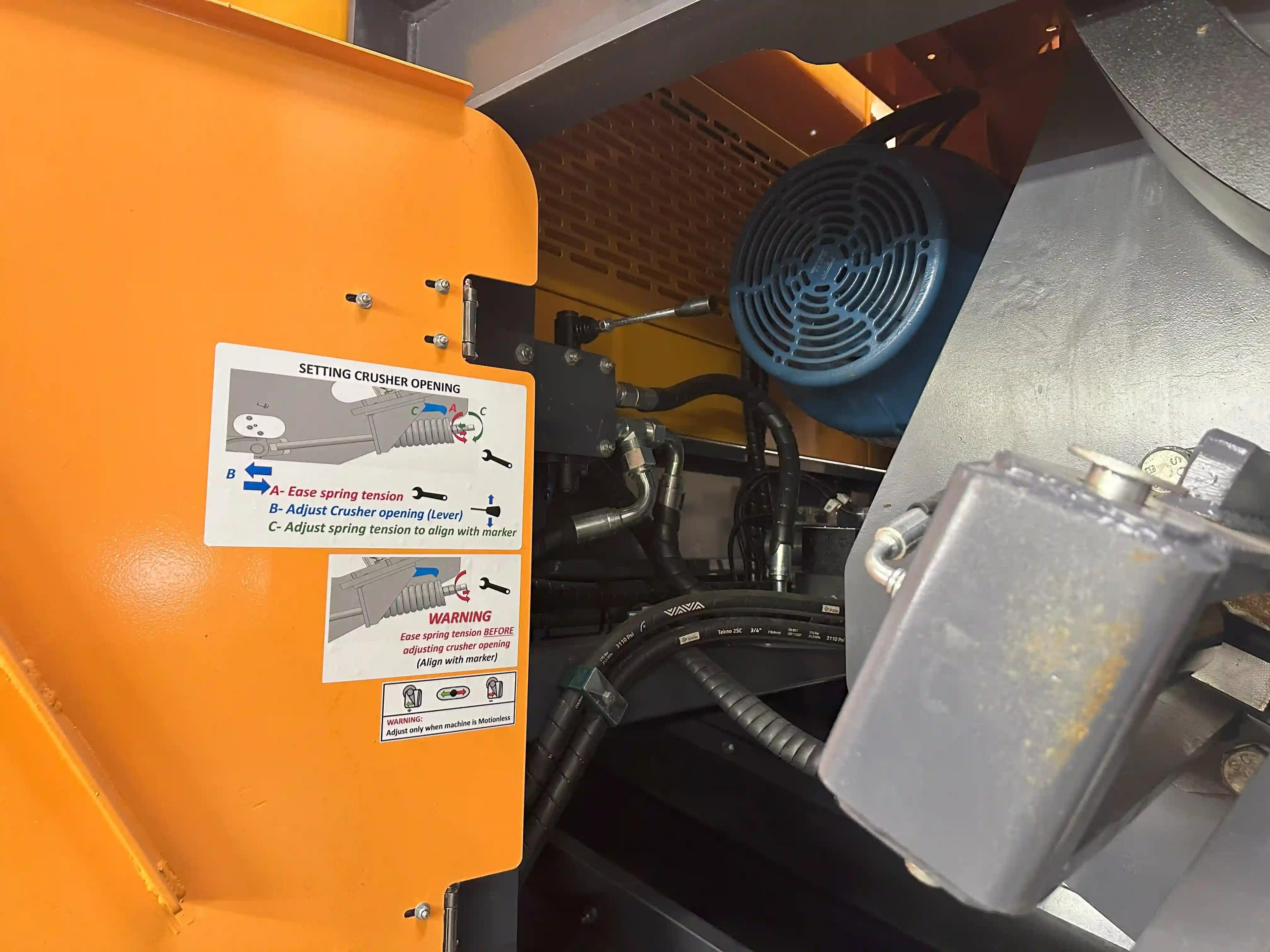 inside The Barford 750J RS which comes with hydraulic jaw adjustment but requires some manual tightening or loosening of the spring bolt to maintain a secure tensioning. stickers show the operator what needs to be done