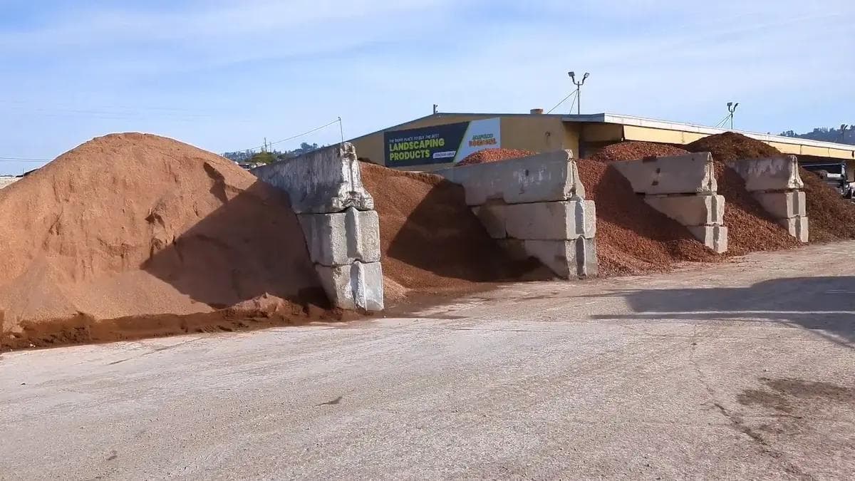 range of concrete bins filled with red stone separated into different sizes