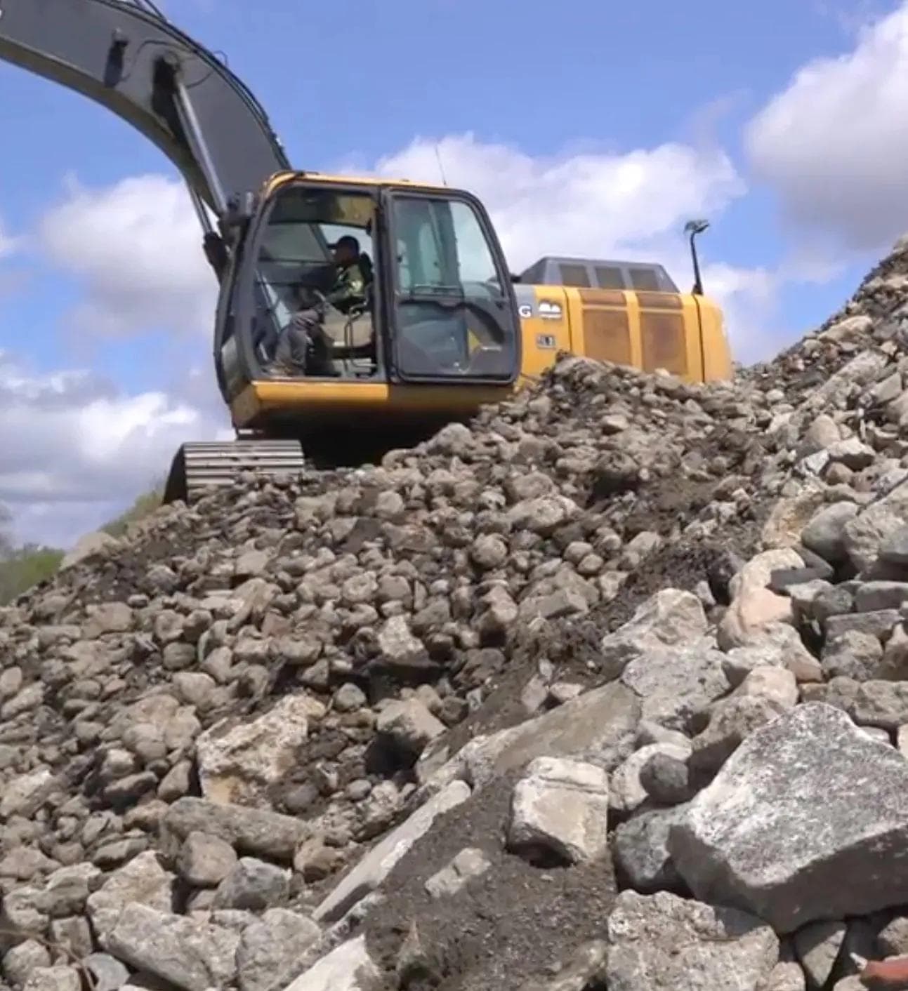 excavator moving waste concrete and rubble