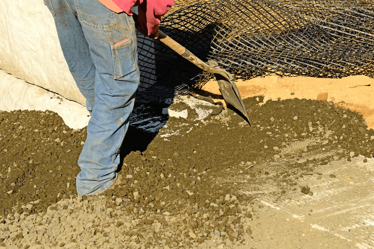 worker putting stones down to provide drainage before concrete is poured