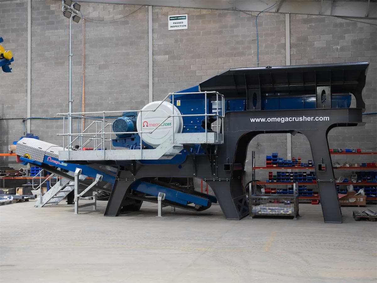gray and blue static omega jaw crusher inside a warehouse