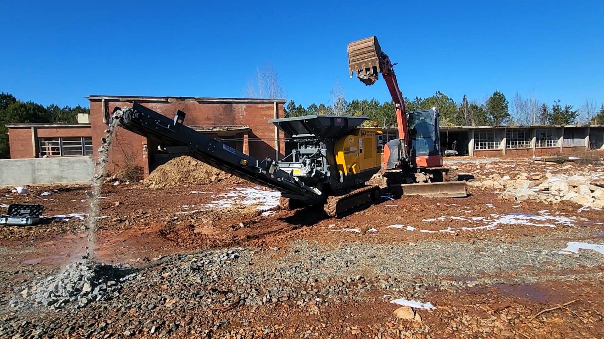 rubblecrusher rcj65t crushing concrete on site and being fed by an excavator