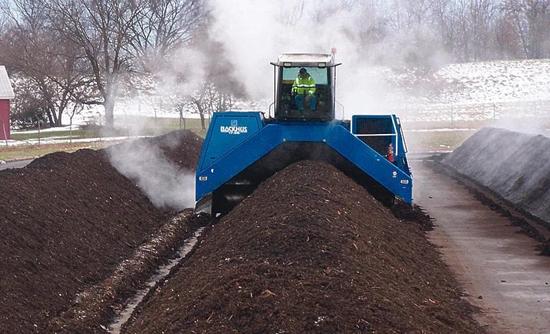 machine turning a row of compost