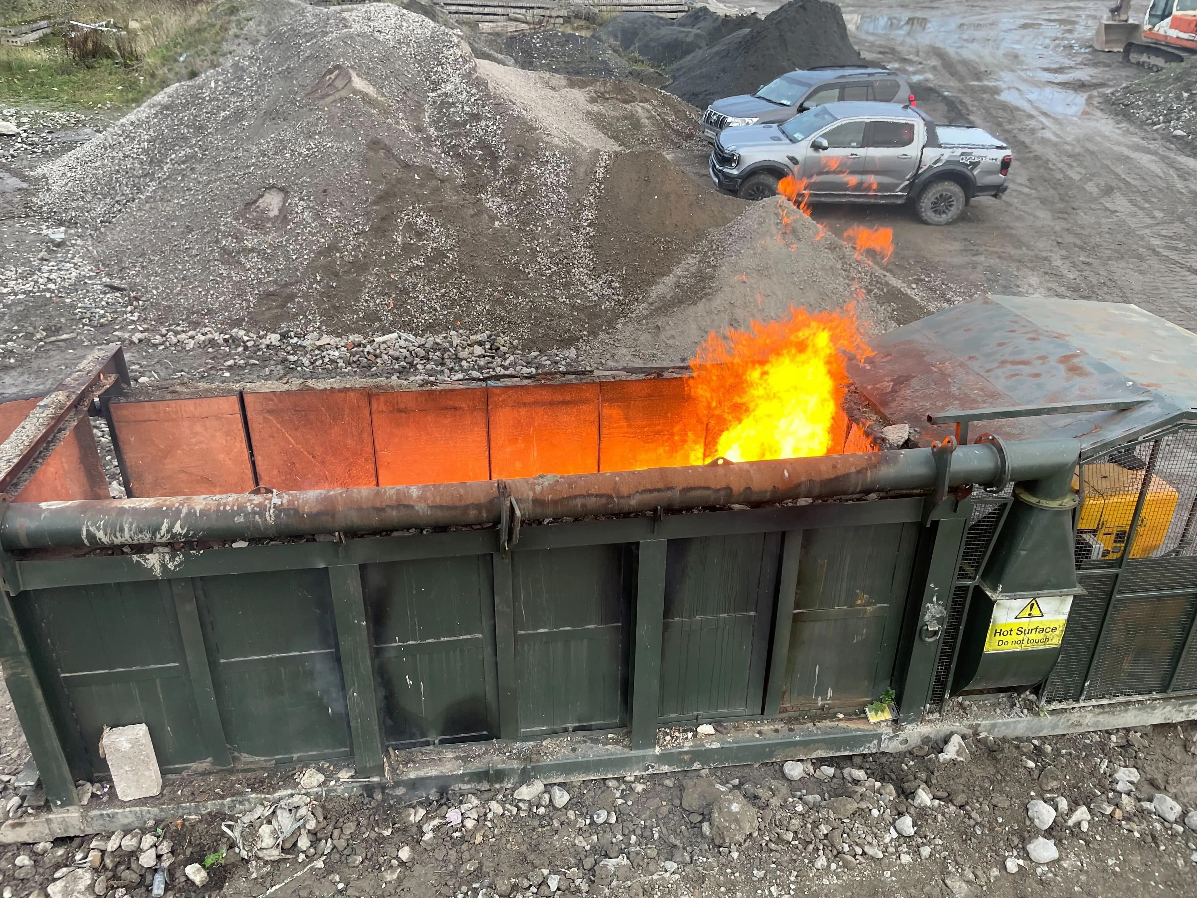 Merris air curtain burner running a load of wood waste material