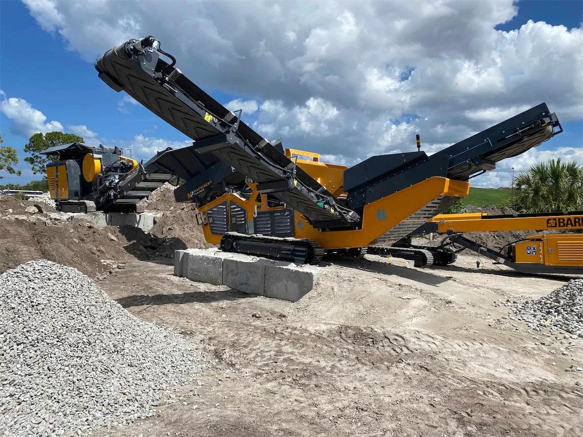 screener on site being used to separate stone into three piles of different sizes