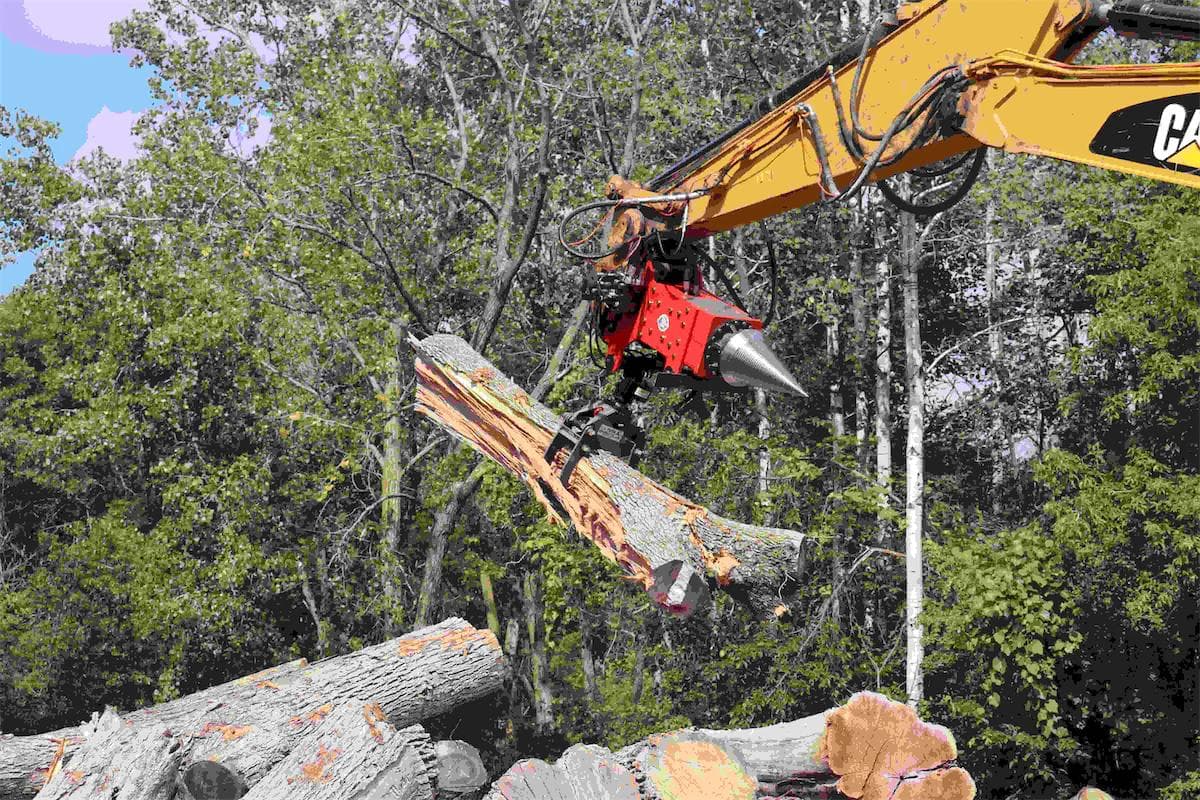 red u.s. pride products cone splitter with grapple attachment moving and splitting large logs while attached to a cat excavator.