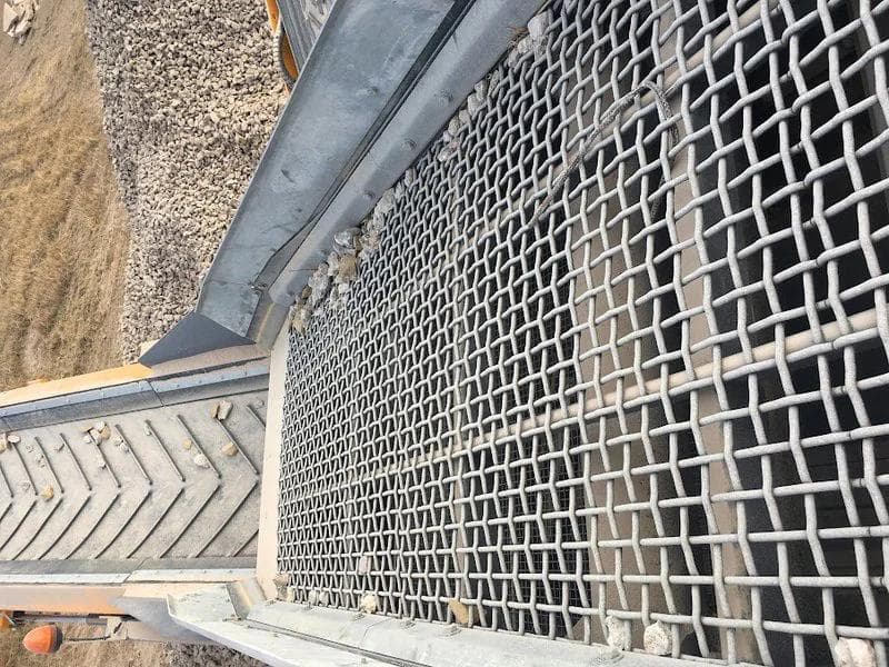 woven wire mesh on a screen deck which is being used to screen rocks